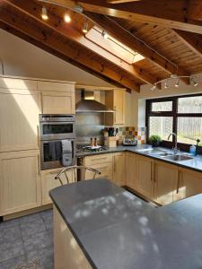 a kitchen with wooden cabinets and a stove top oven at Redcot Gardens Stamford 4 bed contractor familt home with Parking in Stamford
