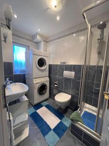 a bathroom with a shower and a toilet and a sink at DG Ferienwohnung TLA Ramstein in Ramstein-Miesenbach