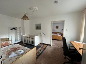 a bedroom with a bed and a desk and a room with a bed at DG Ferienwohnung TLA Ramstein in Ramstein-Miesenbach