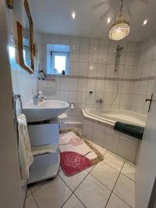 a bathroom with a sink and a bath tub at DG Ferienwohnung TLA Ramstein in Ramstein-Miesenbach