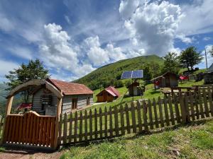 a small house with a fence and a solar panel at Katun Lanista-Kolibe Bogavac in Mojkovac