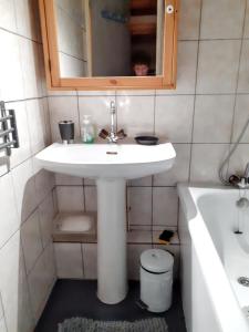 ein Badezimmer mit einem weißen Waschbecken und einer Badewanne in der Unterkunft Studio a Allos a 100 m des pistes avec balcon amenage in Allos