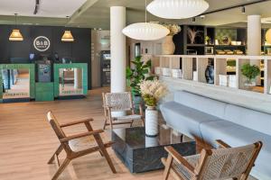 eine Lobby mit Stühlen und einem Tisch in einem Laden in der Unterkunft B&B HOTEL Barcelona Granollers in Les Franqueses del Vallès