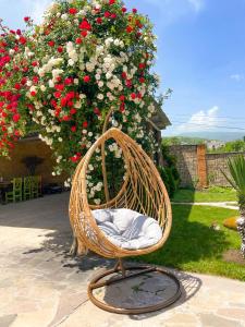 a wicker chair in front of a bush of flowers at ECO PARK RESORT in Ijevan