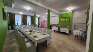 Hotel Chańcza في Raków: غرفة طعام مع طاولة طويلة وجدران خضراء