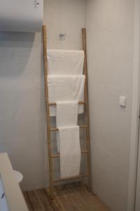 a towel rack in a bathroom with white towels at Estancia dos Olivos in Quesa