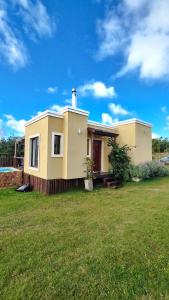 a small yellow house with a grassy yard at Marrakech Villa Serrana in Villa Serrana