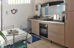 a kitchen with a table and a stove top oven at Maison de 2 chambres a l'Etang Sale les Bains a 30 m de la plage avec jardin clos et wifi in Étang-Salé les Bains