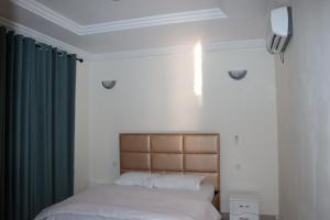 a bedroom with two beds and a green curtain at Résidence as salam in Yaoundé