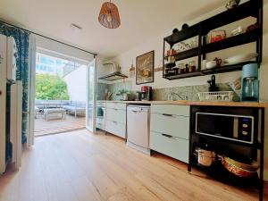 a kitchen with white cabinets and a wooden floor at LocBreuillet91 in Breuillet