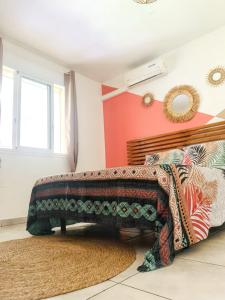ein Schlafzimmer mit einem Bett mit einer Decke darauf in der Unterkunft Appartement d'une chambre avec piscine partagee jardin clos et wifi a Le Gosier in Le Gosier