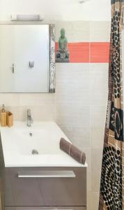 ein Bad mit einem Waschbecken und einem Spiegel in der Unterkunft Appartement d'une chambre avec piscine partagee jardin clos et wifi a Le Gosier in Le Gosier