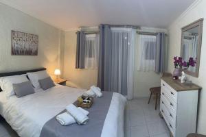 a bedroom with a white bed with pillows and a dresser at ARGO Downtown Apartment in Kalymnos