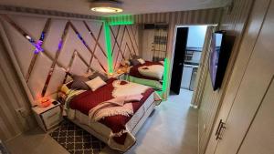 una camera da letto con due letti in una stanza con luci verdi di Gold House Oro a Quito