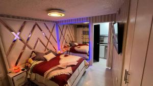 una camera con due letti in una stanza con illuminazione viola di Gold House Oro a Quito Altre 2 foto