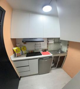 una piccola cucina con armadi bianchi e lavandino di Gold House Oro a Quito