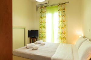 a bedroom with a white bed with two towels on it at Windmill 23 Apartment in Agios Nikolaos