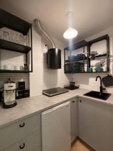 a kitchen with white cabinets and a sink and a counter at Apartament Pod Piórkiem in Krościenko +17 photos