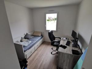 a bedroom with a bed and a desk with a computer at Maison 5 places proche circuit 24 heures in Fillé