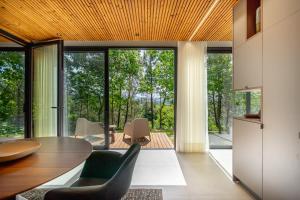 a dining room with a table and chairs and large windows at Villas Prendal Eco Living - Minho's Guest in Guimarães