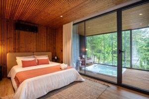 um quarto com uma cama e vista para uma piscina em Villas Prendal Eco Living - Minho's Guest em Guimarães