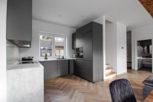 a kitchen with white and black cabinets and a counter at Posti villa 2 in Pärnu