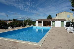 a swimming pool in front of a house at La Bastide des Lavandieres - Apartment Cerise in Canaules-et-Argentières