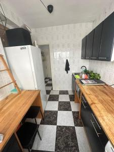 a kitchen with a white refrigerator and a checkered floor at Habitación 2 en tercera planta sin ascensor no és un piso entero! A compartir Baño y cocina! in Fuengirola