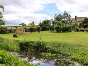 un jardin avec un étang et un kiosque dans l'établissement Bride Cross Granary, à Otley