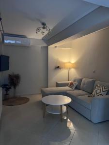 uma sala de estar com um sofá e uma mesa em Sea Front Retreat em Cavala