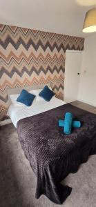 Una cama con un peluche azul encima. en 7 Guest 4 Bedrooms CITY CENTRE lovely home in Loughborough City Centre, en Loughborough