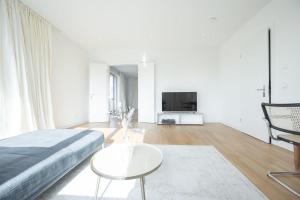 a white room with a bed and a table and a tv at Dr. Bockemüller Appartements 