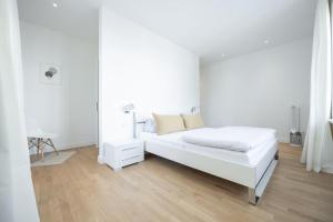 a white bedroom with a bed and a mirror at Dr. Bockemüller Appartements 