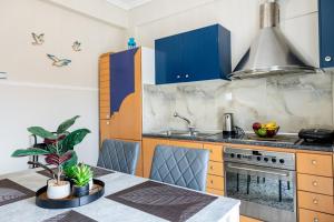 a kitchen with blue cabinets and a table with a plant at Teo Apartment in Iraklitsa