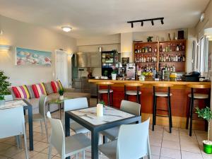 un restaurant avec un bar, des tables et des chaises dans l'établissement Theos Holidays Apartments, à Kato Daratso