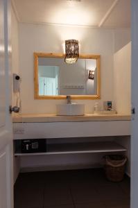 een badkamer met een wastafel en een spiegel bij El Mosquito Boutique Hotel Playa Bonita in Las Terrenas