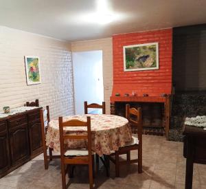 a dining room with a table and chairs and a fireplace at Departamento amplio a metros del mar in Puerto Madryn