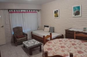 a bedroom with a bed and a chair and a table at Departamento amplio a metros del mar in Puerto Madryn +6 photos