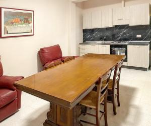 eine Küche mit einem Holztisch und Stühlen in der Unterkunft 2 bedrooms apartement with city view and terrace at Torre Melissa in Torre Melissa
