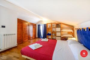 een slaapkamer met een groot bed en een rode deken bij La Mansarda di Lory in La Spezia