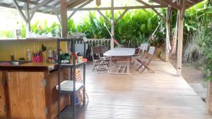un patio avec une cuisine, une table et des chaises dans l'établissement Bungalow de 2 chambres avec piscine partagee jardin amenage et wifi a Le Robert a 1 km de la plage, à Le Robert