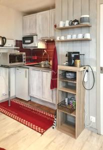 cocina con armarios blancos y alfombra roja en Studio a Uvernet Fours a 200 m des pistes avec terrasse amenagee en Uvernet