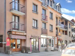 a pink building on a city street with shops at Studio a Aiguilles a 5 km des pistes in Aiguilles