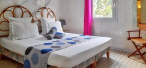 ブイヤントにあるBungalow de 2 chambres a Bouillante a 150 m de la plage avec terrasse amenagee et wifiのベッドルーム1室(大型ベッド1台、青と白の枕付)