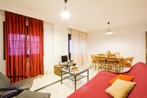 a living room with a red couch and a table at Entre la Alhambra y Sierra Nevada in Monachil