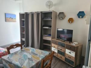um quarto com uma cama, uma cómoda e uma televisão em Chanoine Boursier em Dol-de-Bretagne