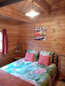een slaapkamer met een bed in een blokhut bij CAMPING LA PERLE in La Rochette