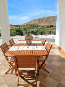 una mesa de madera con sillas y vistas a la montaña en 3 bedrooms apartement with sea view and furnished garden at Montallegro 2 km away from the beach, en Montallegro