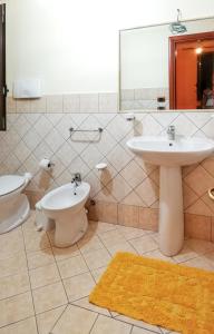 een badkamer met een wastafel, een toilet en een spiegel bij 3 bedrooms apartement with sea view and furnished garden at Montallegro 2 km away from the beach in Montallegro