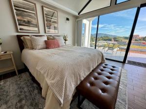 a bedroom with a large bed and a large window at SUR del Valle in Valle de Guadalupe